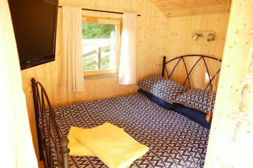 a bedroom with a bed in a room with a window at The Lookout Shepherd's Hut in Dolton