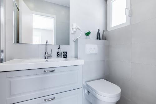 a white bathroom with a sink and a toilet at 4 Elements Old Town Views Rooms in Trogir