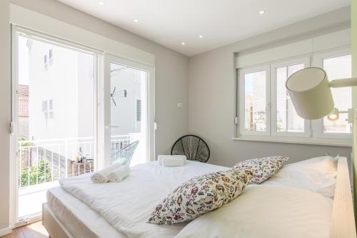 a bedroom with a bed with pillows and a window at 4 Elements Old Town Views Rooms in Trogir