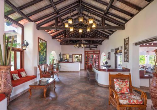 a living room with a ceiling with a chandelier at Sugar Cane Club Hotel & Spa in Saint Peter