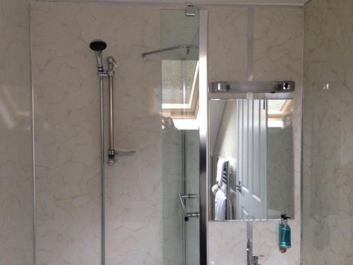 a bathroom with a shower with a glass door at Oakside Lodge Guest House in Canterbury