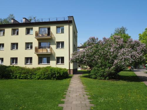 a building with a flowering tree in front of it at Roman in Druskininkai