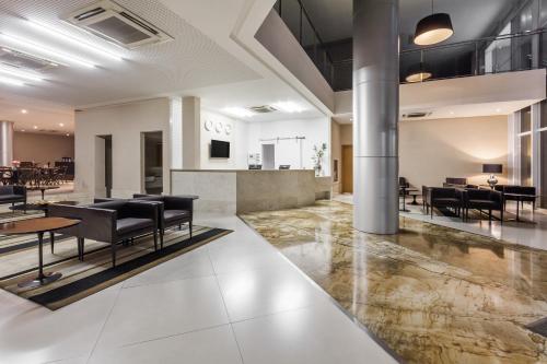 a lobby of a building with black chairs and tables at Days Inn by Wyndham Linhares in Linhares