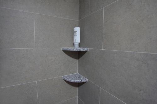 萨拉热窝Deluxe Bellevue Apartments的配有白色遥控器的瓷砖淋浴间