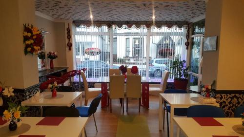 a restaurant with tables and chairs and a large window at BUKHARI Hotel in Blackpool
