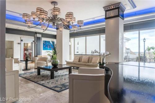 a living room with a chandelier and a table at Oceanview on SAND located in Ocean Manor Resort Fort Lauderdale Beach 2 bed 2 bath spacious corner unit partial ocean view in Fort Lauderdale