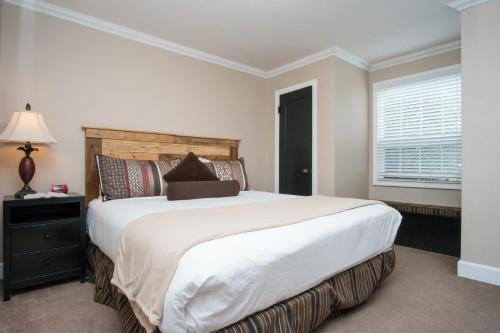 a bedroom with a large white bed and a window at Ecola Creek Lodge in Cannon Beach