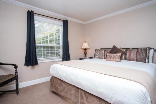 a bedroom with a large white bed and a window at Ecola Creek Lodge in Cannon Beach