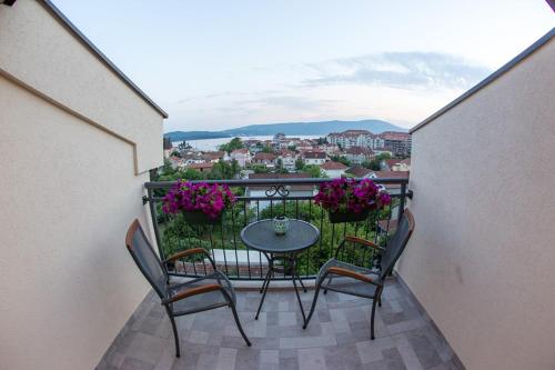 a balcony with a table and two chairs and flowers at Porto Apartments in Tivat