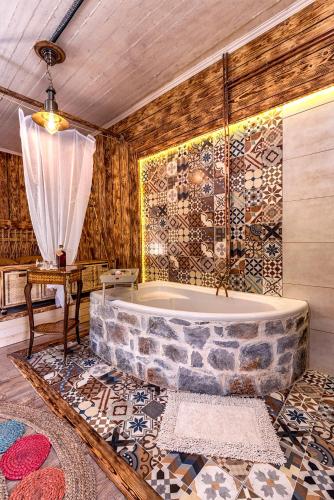 a bathroom with a stone tub and a table at Krassopsychia Apartments in Krásion