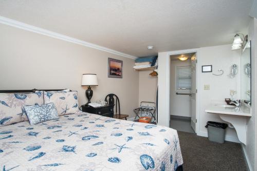 a bedroom with a bed and a sink at Ecola Creek Lodge in Cannon Beach