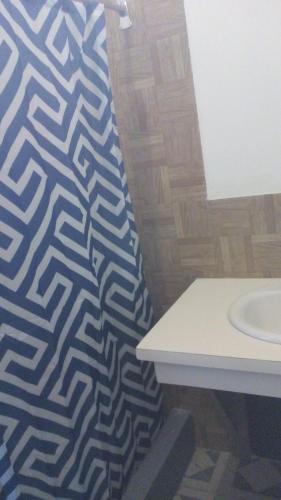 a bathroom with a blue and white pattern on the wall at Drifters@One Mile in Negril