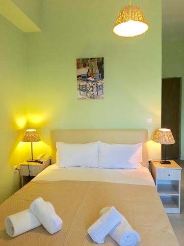 a bedroom with a bed with two towels on it at Venus Beach Hotel in Nea Stira