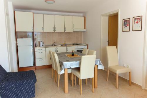 a kitchen with a table and chairs in a room at Guesthouse Lamia in Neum