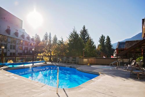 
a swimming pool with a pool table and chairs at Whistler Village Inn & Suites in Whistler
