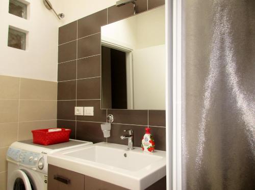 a bathroom with a sink and a washing machine at Appartamento Sissi, romantico in centro in Levico Terme