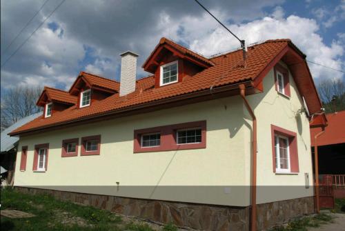 a white house with a red roof at Mansarda in Mýto pod Ďumbierom