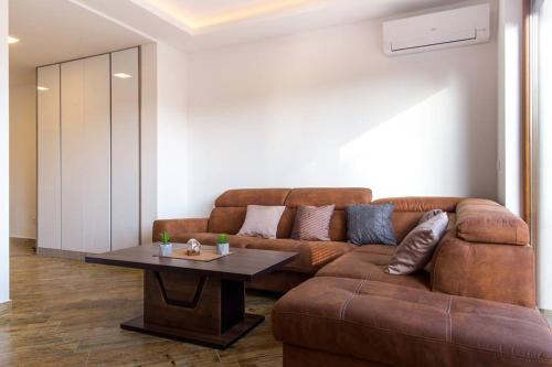 a living room with a brown couch and a table at Porto Apartments in Tivat