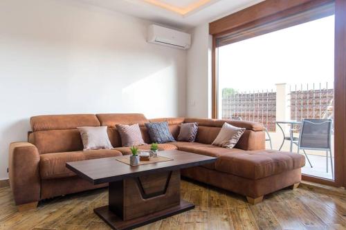 a living room with a brown couch and a table at Porto Apartments in Tivat