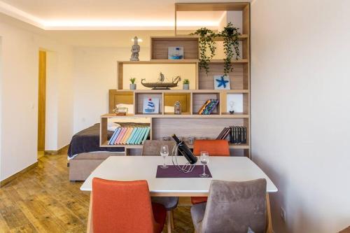 a room with a table and chairs and a bed at Porto Apartments in Tivat