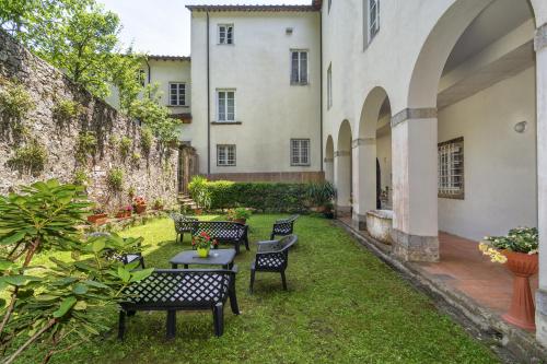 een binnenplaats van een gebouw met stoelen en een tafel bij Casa Diocesana di Lucca in Lucca