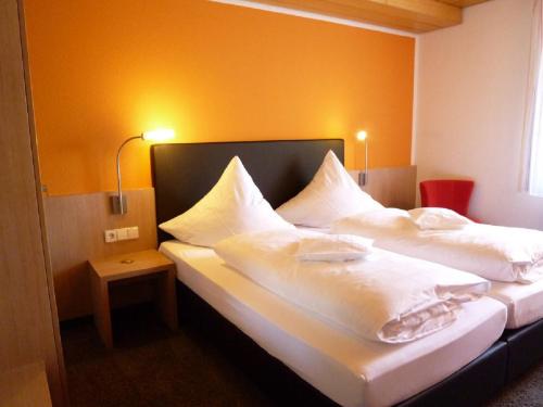 a bedroom with two beds with white sheets and pillows at Gasthof zum Bad in Langenau
