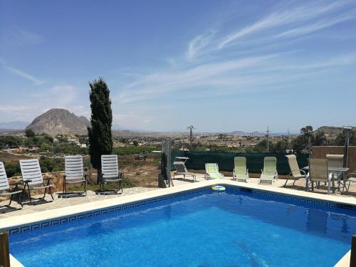 uma piscina com cadeiras e vista para uma montanha em Finca San Diego, villa entera para ti em Vallonga