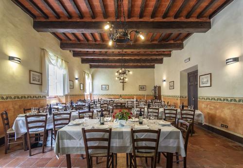 Casa Diocesana di Lucca في لوكّا: غرفه كبيره فيها طاولات وكراسي