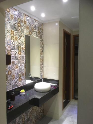 a bathroom with a sink and a mirror at Pousada Circuito das Águas in Caxambu