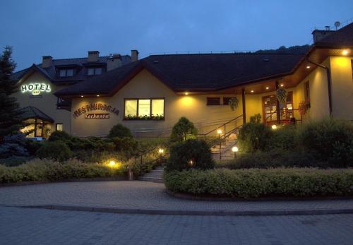 a house with lights on the side of it at Hotel Kochanów in Kochanów