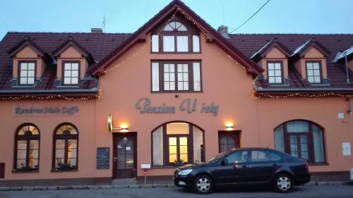 a black car parked in front of a building at Penzion U řeky in Vojkovice