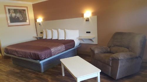 Habitación de hotel con cama y silla en River Valley Motor Inn, en La Grange