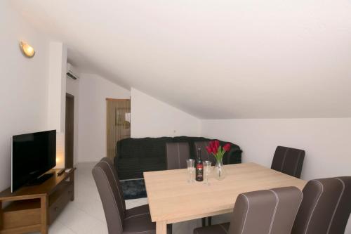 a dining room with a table and a couch at Apartments Katarina in Pirovac