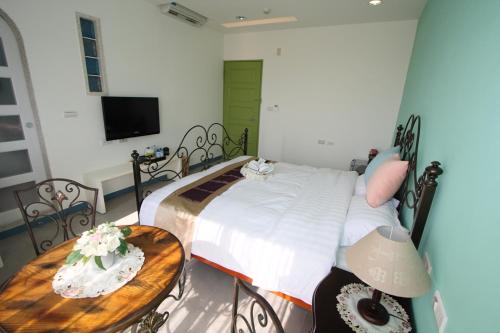 馬公市にあるDaydream B&B 白日夢海景旅店のベッドとテーブルとテレビのある寝室