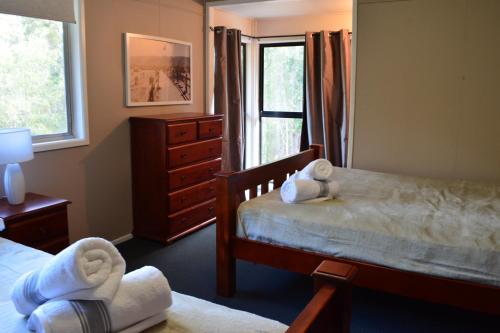 1 Schlafzimmer mit 2 Betten, einer Kommode und einem Fenster in der Unterkunft Eatons Retreat in Eatons Hill