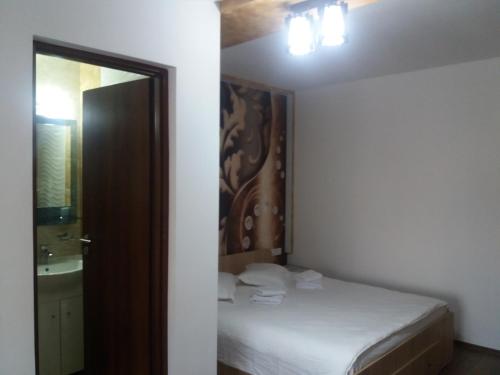a small bedroom with a bed and a mirror at Casa Lipianu in Târgu Jiu