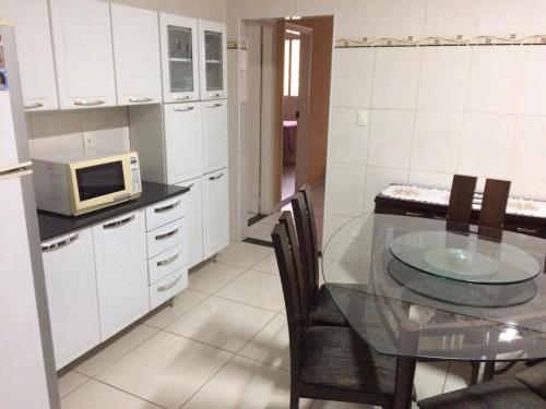 a kitchen with a glass table and a microwave at Casa Familiar em Campinas com 2 Quartos, 1 banheiro, 1 vaga para carro in Campinas