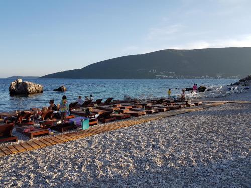 a group of people sitting in chairs on a beach at Apartments Astoria HN in Herceg-Novi