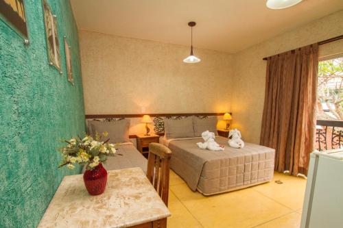 a bedroom with a bed and a table in a room at Pousada Brasil Nativo in Cabo Frio