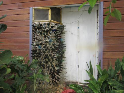 a bunch of wine bottles on the side of a building at Anda Di Hows Hostel in Placencia Village