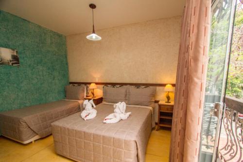 two stuffed animals sitting on two beds in a room at Pousada Brasil Nativo in Cabo Frio