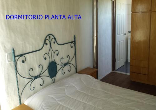 Schlafzimmer mit einem weißen Bett mit einem Kopfteil aus Metall in der Unterkunft Alora in Piriápolis