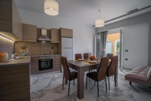 een keuken met een tafel en stoelen in een kamer bij Katsaros Luxury Apts 5min walk to beach in Tsilivi