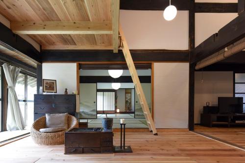 a room with a loft with a ladder and a chair at さいの郷「椛」 in Kagamino