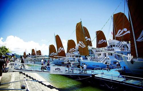 a group of boats are docked at a dock at Queen Motel in Ha Long