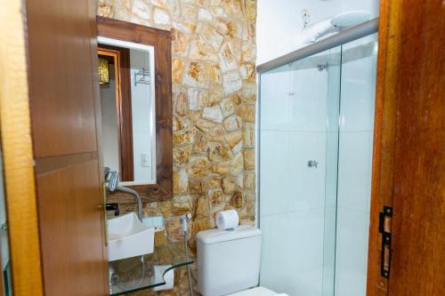 a bathroom with a shower and a toilet and a sink at Pousada Brasil Nativo in Cabo Frio