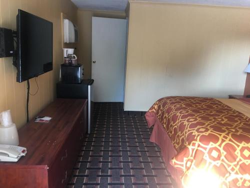 a hotel room with a bed and a flat screen tv at Royal Inn in Early