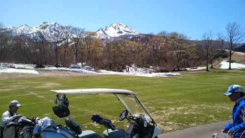 a group of motorcycles parked next to a golf course at Lodge Amenouo in Myoko