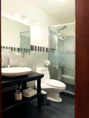 a bathroom with a toilet and a sink and a shower at Illa Hotel in Cusco