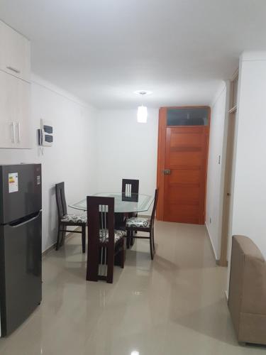 a kitchen and dining room with a table and a door at Nino´s Residence Departamentos VIP Amoblados in Tacna